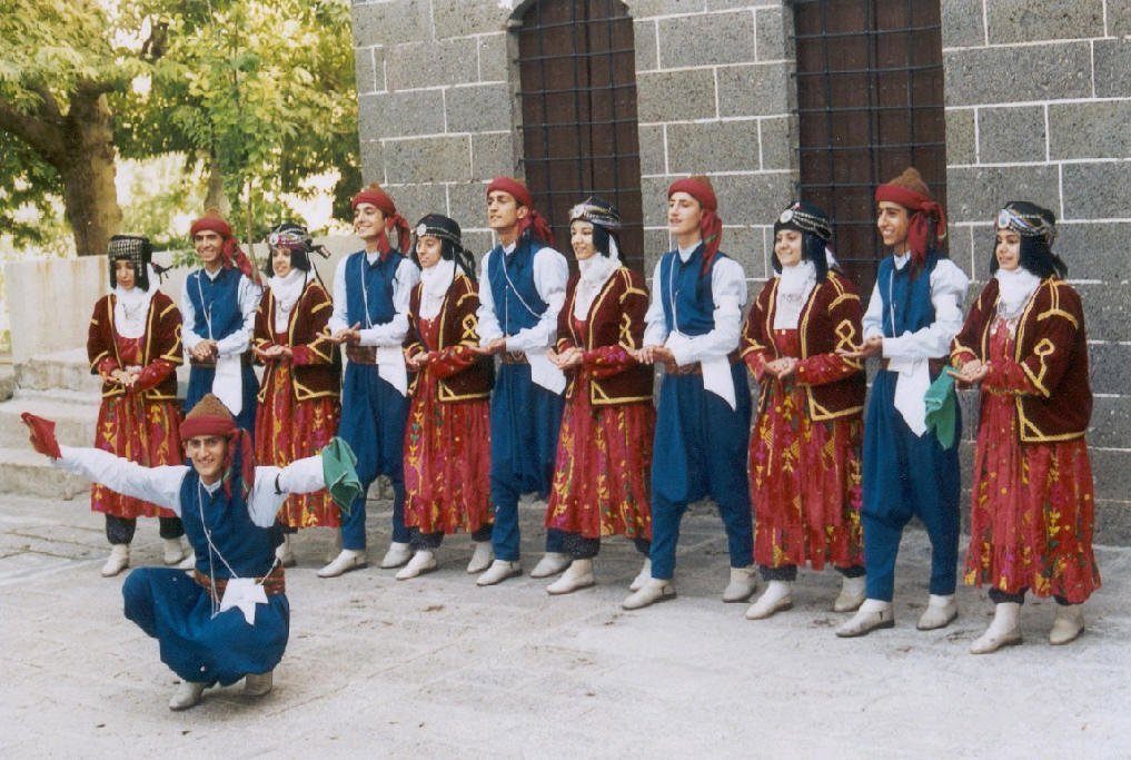 A line of Anatolian folk dancers performing in traditional dress
